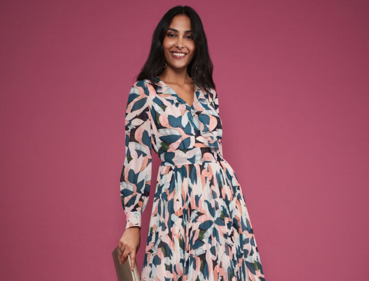 Woman wearing maxi dress, holding a clutch bag